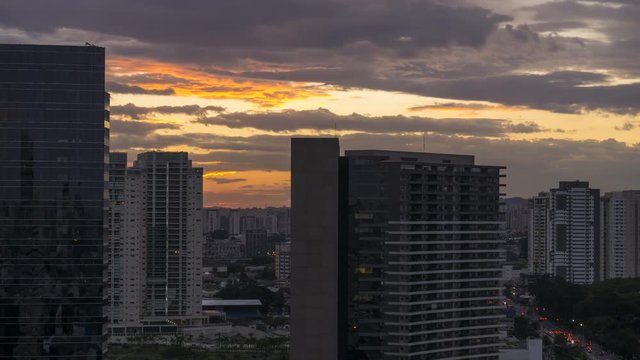 Sunset time lapse during twilight in urban landscape with cars moving on avenue and among buildings in S&atilde;o Paulo City Brasil