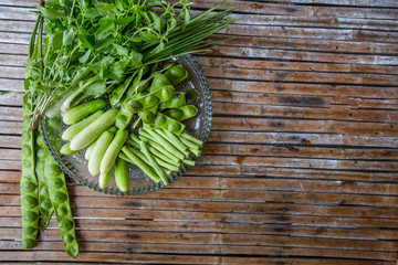A view of the arrangement of a close-up food set,a healthy vegetable set (cucumber,sato,long-hatched bean)that is placed in a beautiful container and placed on a wooden stick to serve customers again.