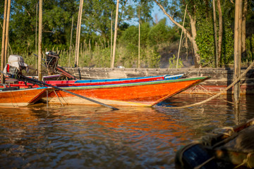 The background of the long tail boat that is parked in the river is blurred and the wind blows all the time, the head made of wood is strong and can be used for a long time