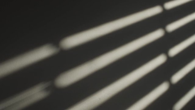 Shadow on wall of window shutters openning in slow motion