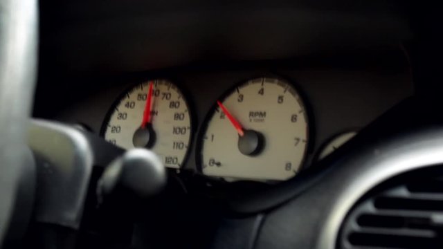 Driving 60mph down the highway in small car looking at the dials and gauges