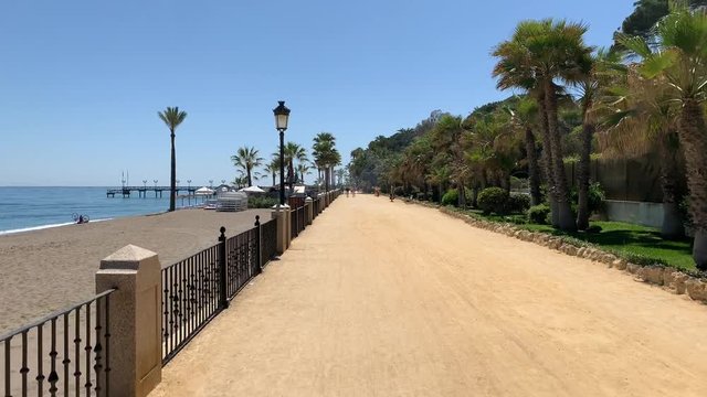pov walk on paseo maritimo de marbella. 
natural walking motion.
summer walk next to the beach along teh golden mile in marbella, spain. 
spanish vacation holiday