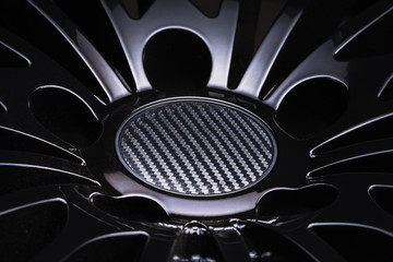 new Luxury Black alloy Wheel, sporty with thin spokes and carbon cap, close-up on black background