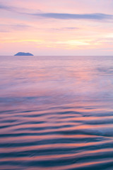 Obraz premium A tranquil beach and ocean waves at sunset.