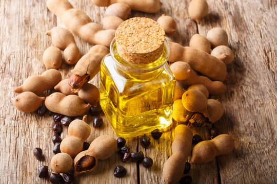 Tamarind seed oil in a glass jar close-up on a table. vertical