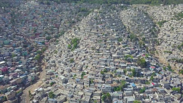 Amazing aerial reveals the endless slums, favelas and shanty towns in the Cite Soleil district of Port Au Prince, Haiti with soccer stadium foreground.