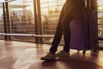 Fototapeta premium Woman traveler waiting airplane after booking ticket flight at airport with carrying,backpack,suitcase luggage for tranport travel international vacation time in holiday relaxation.