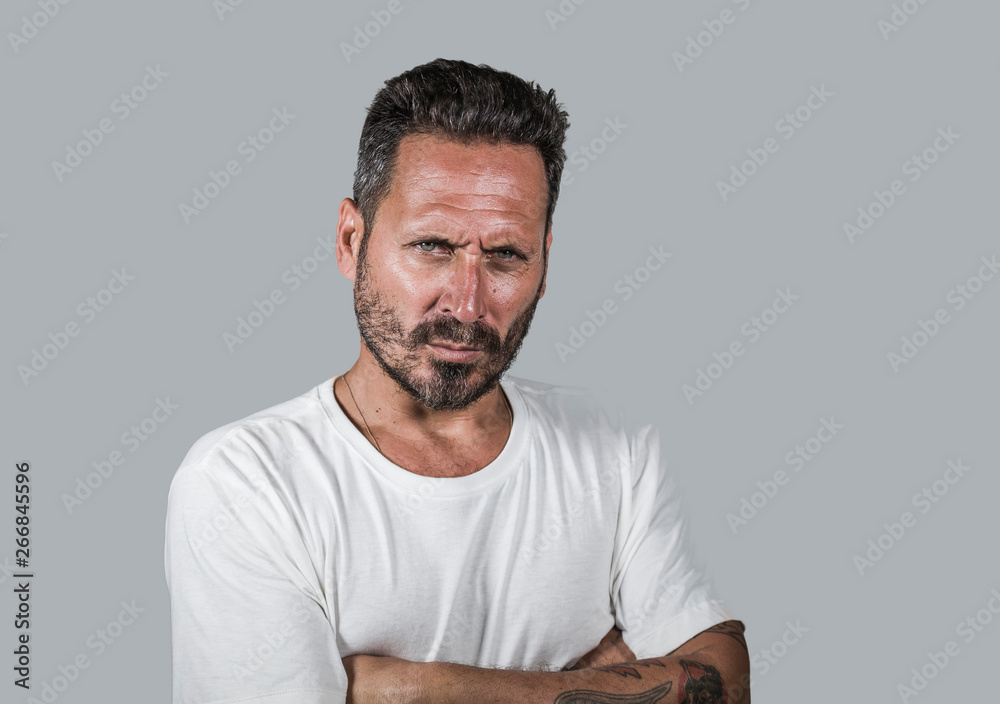 Wall mural handsome and attractive man with beard looking with intense eyes staring directly inquisitive and up