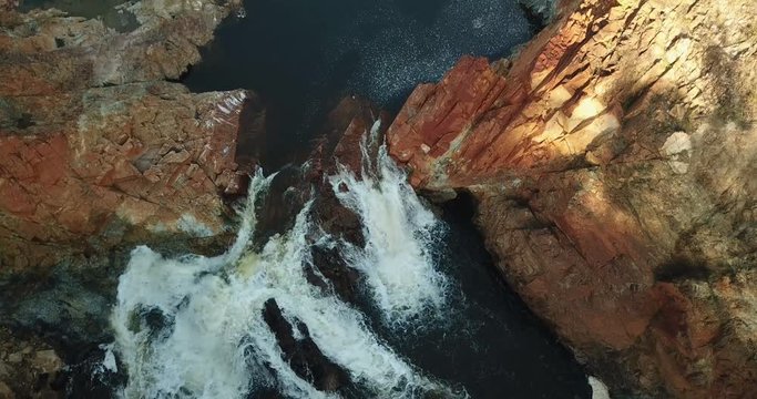 Aerial view of water foaming between the rocks.