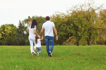 Back view. Family with children walks in the park.