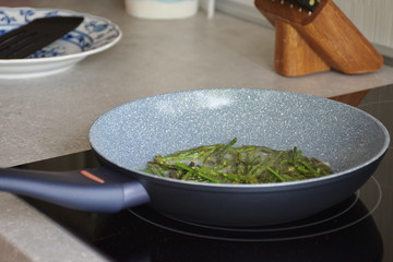 Preparing asparagus on the stove in the kitchen