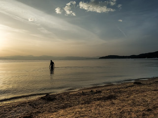 silhouette of a man walks into the sea at sunrise. landscape from Corfu (Kerkyra)