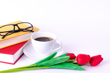 Cup of coffee over white background with red book and glasses. Copy space for advertiser.