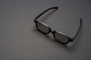 Fototapeta na wymiar Black plastic dark sunglasses on dark background. Eye care and diseases concept, eye protection.