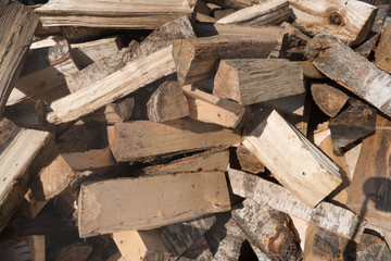 Firewood background - chopped firewood on a stack. Dry chopped firewood logs in a pile. Preparation of firewood for winter or summer season. Close-up