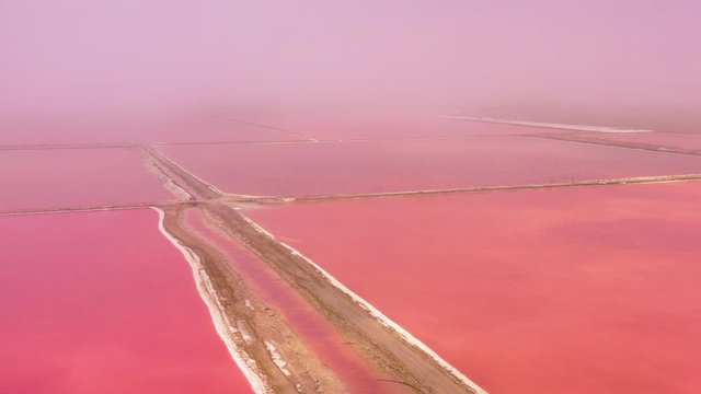 Beautiful aerial over bright red and pink salt pan farms near Walvis Bay, Namibia.