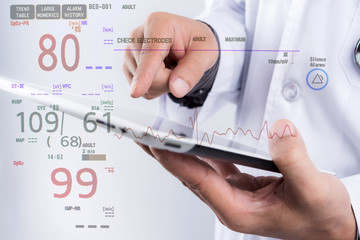 Doctor hold tablet in hand with electrocardiogram monitor showing patient heart rate, medical rescue concept.