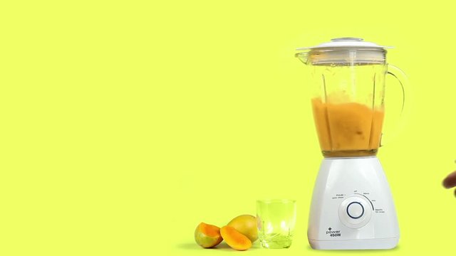 mango juice with a blender, isolated on a yellow background