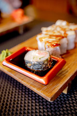 Traditional Asian food sushi on wooden plate.