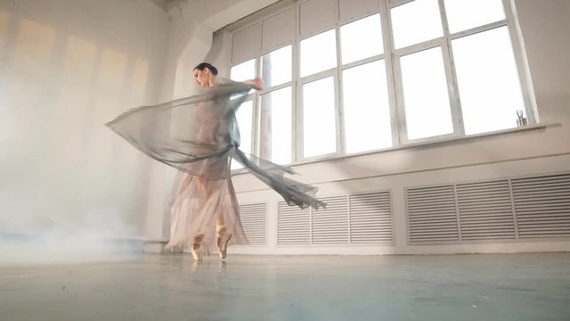 Modern ballet dancer in scenic flowing costume working out at studio during final reheasal . Art concept. Inspiration.