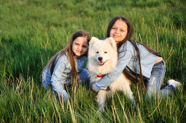 Cute sisters with dog outdoors.