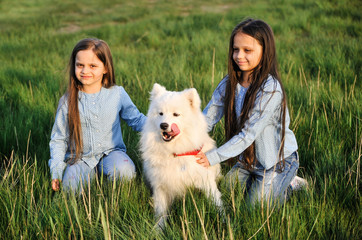 Cute sisters with dog outdoors.
