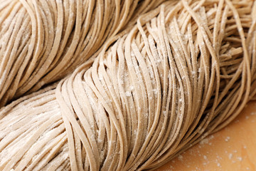 生そば　Raw soba noodles on wooden board background.