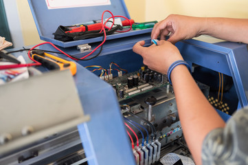 Technician repairing mainboard of colors dispensers of inkjet printer