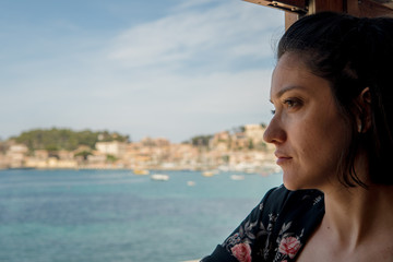 Young woman travelling alone on train. Beautiful view Port de Sóller in Mallorca island 