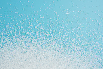 White sugar splash on blue background texture top view