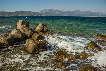 stone rocky beach Mediterranean waterfront scenic outdoor landscape vivid blue water surface with waves