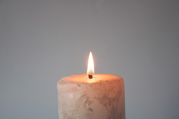 Fototapeta na wymiar a big white candle burns in the dark