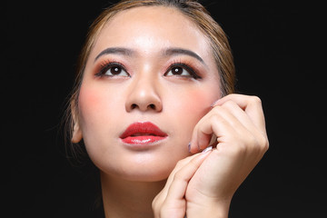 Young beautiful Asian woman makeup dark background 