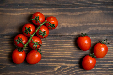 Fototapeta na wymiar Fresh cherry tomatoes on a dark wood background.