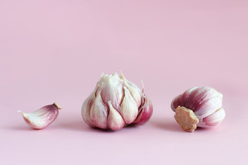 Fresh garlic on a light pink background