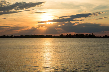 Fototapeta premium scenic orange sunset with beautiful clouds and blue sky on the river danube