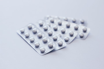White pills plastic blisters on white background. 