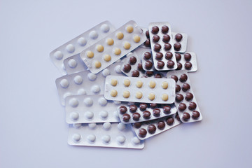 Set of many different colours pills blisters on white background. 