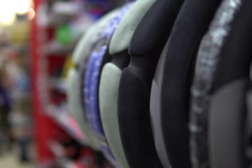 Automobile steering wheel covers hanging in department of spare parts for cars.