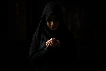 Muslim women wearing black shirts Doing prayer According to the principles of Islam..