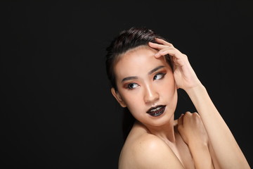 Fototapeta premium Young beautiful Asian woman makeup dark background 