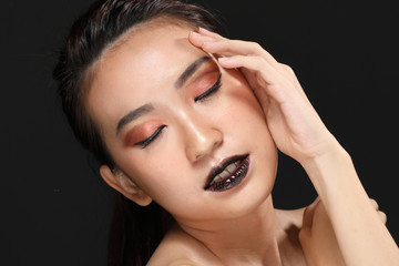 Fototapeta premium Young beautiful Asian woman makeup dark background 