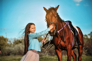 Beautiful girl with horse on the grass. Friendship concept.