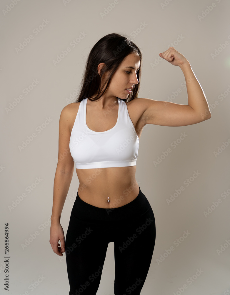 Wall mural portrait of sporty beautiful brunette woman in sport clothes looking sensual and fit