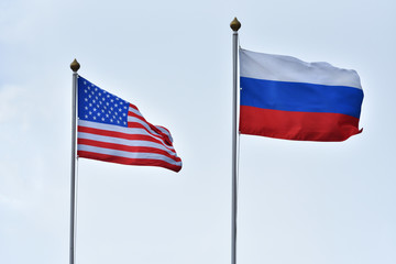 Beautiful and bright flags of the Russian Federation and the United States of America against the sky. Flags of Russia and America as a symbol of friendship and multipolar world and equality