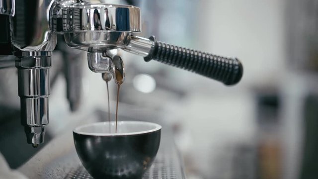fresh coffee from espresso machine brew into coffee cup and steam, ready to make latte