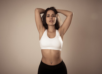 Fototapeta na wymiar Portrait of sporty beautiful brunette woman in sport clothes looking sensual and fit
