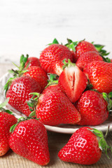 Fresh strawberries in plate on wood
