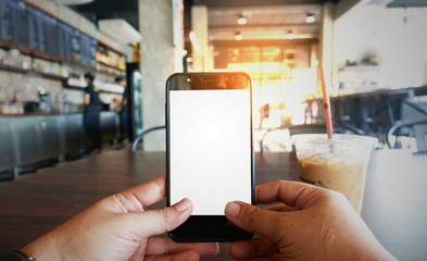 Hand holding mobile at coffee shop