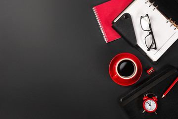 Office desk table with red cup of coffee and notebooks